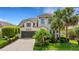 Charming two-story home featuring a well-manicured lawn, lush landscaping, and an attached two-car garage at 843 Molly Cir, Sarasota, FL 34232