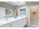 Bathroom featuring a large vanity with double sinks, neutral walls, and access to the water closet and bedroom at 8579 54Th Avenue E Cir, Bradenton, FL 34211