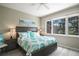 Bright bedroom featuring a king-size bed, neutral walls, and a large window overlooking serene landscaping at 8579 54Th Avenue E Cir, Bradenton, FL 34211