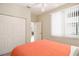 Bedroom with closet, window, and a queen size bed with orange bedding; perfect for relaxation and rest at 8579 54Th Avenue E Cir, Bradenton, FL 34211