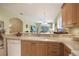 Kitchen with wood cabinets and light countertops has an open view into the living room at 8579 54Th Avenue E Cir, Bradenton, FL 34211