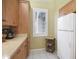 View of a kitchen featuring wood cabinets, light countertops, and white refrigerator at 8579 54Th Avenue E Cir, Bradenton, FL 34211