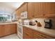Kitchen showcases wood cabinetry, tile flooring, with white appliances and light countertops at 8579 54Th Avenue E Cir, Bradenton, FL 34211