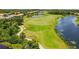 Picturesque aerial view of a lush golf course, a tranquil lake, and beautiful surrounding homes at 8906 Stone Harbour Loop, Bradenton, FL 34212