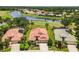 Aerial view showcasing the home's location on a golf course with water views and neighboring houses at 8906 Stone Harbour Loop, Bradenton, FL 34212
