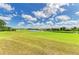 Serene backyard featuring a pond, lush greenery, and beautiful homes in a peaceful setting at 8906 Stone Harbour Loop, Bradenton, FL 34212