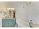 Bright bathroom featuring a standalone tub, beadboard wall accents, and a vanity with a speckled countertop at 8906 Stone Harbour Loop, Bradenton, FL 34212