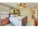 Comfortable bedroom with a wooden bed frame, ceiling fan, and view into the en suite bathroom at 8906 Stone Harbour Loop, Bradenton, FL 34212