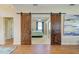Bedroom entrance features sliding barn doors, hardwood floors, and blue accent pillows on the bed at 8906 Stone Harbour Loop, Bradenton, FL 34212