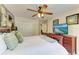 Comfortable bedroom with a wooden bed frame, ceiling fan, and dresser with television at 8906 Stone Harbour Loop, Bradenton, FL 34212