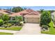 Charming single-story home featuring a red tile roof, a two-car garage, and lush landscaping in a well-maintained yard at 8906 Stone Harbour Loop, Bradenton, FL 34212