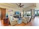Comfortable living room with large TV, wood floors, and sliding glass doors at 8906 Stone Harbour Loop, Bradenton, FL 34212
