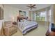 Coastal-inspired bedroom with a comfortable bed, ceiling fan, and large windows offering serene views at 8906 Stone Harbour Loop, Bradenton, FL 34212