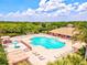Aerial view of the community pool, showcasing lounge seating, a splash pad, and a nearby clubhouse at 8906 Stone Harbour Loop, Bradenton, FL 34212