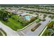 Beautiful aerial view of the community featuring a luxurious pool, well-maintained lawns, and numerous homes at 8937 Excelsior Loop, Venice, FL 34293