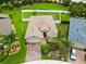 Aerial view of a beautiful home with a brick driveway and lush, landscaped front yard at 8937 Excelsior Loop, Venice, FL 34293
