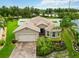 Inviting home features a well-manicured lawn, mature landscaping, and brick paver driveway at 8937 Excelsior Loop, Venice, FL 34293