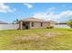Expansive backyard featuring a lush lawn, covered patio, white fence, and exterior view of the single-Gathering home at 8937 Excelsior Loop, Venice, FL 34293