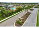 Community sign with landscaped entrance featuring palm trees and lush greenery at 8937 Excelsior Loop, Venice, FL 34293