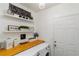 Bright laundry room with stacked washer and dryer, open shelves, and a chandelier for added elegance at 8937 Excelsior Loop, Venice, FL 34293