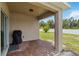 Relaxing covered patio with brick pavers, grill, and a view of the backyard and white vinyl privacy fence at 8937 Excelsior Loop, Venice, FL 34293