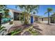 Cozy home exterior featuring brick driveway, blue front door and tropical landscaping at 1116 S Moonmist Ct # M12, Sarasota, FL 34242