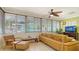 Living room featuring a sectional sofa, ceiling fan, and windows for natural light at 1116 S Moonmist Ct # M12, Sarasota, FL 34242