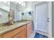 Bathroom featuring a granite countertop, wood cabinets, and a large mirror with an exterior door at 11324 77Th E St, Parrish, FL 34219