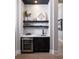 Charming bar with marble countertops, floating shelves, and stainless wine refrigerator at 1162 Blue Shell Loop, Sarasota, FL 34240