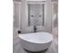 Bright bathroom featuring a modern soaking tub, decorative tile, and elegant fixtures at 1162 Blue Shell Loop, Sarasota, FL 34240