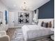 Bedroom featuring a modern chandelier, statement art, and light hardwood floors at 1162 Blue Shell Loop, Sarasota, FL 34240