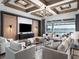 Modern living room boasting coffered ceilings, stylish furniture, and a view of the pool and lake at 1162 Blue Shell Loop, Sarasota, FL 34240
