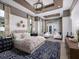 Luxurious main bedroom featuring a decorative ceiling, ample natural light, and a sitting area at 1162 Blue Shell Loop, Sarasota, FL 34240