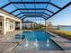 Beautiful screened-in pool with water features, adjacent to a patio, and views of the tranquil waterfront at 1162 Blue Shell Loop, Sarasota, FL 34240