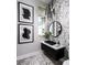 Elegant powder room with patterned tile walls, a modern vanity, sleek black sink, and decorative light fixture at 1162 Blue Shell Loop, Sarasota, FL 34240