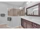 Bright bathroom featuring a walk-in shower with glass partition and dark wood vanity at 1301 Backspin Dr, Englewood, FL 34223