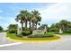 Elegant community entrance with lush landscaping, a manicured roundabout, and a welcoming sign for 'Martinique' at 1301 Backspin Dr, Englewood, FL 34223