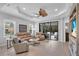 Bright living room featuring neutral paint, stylish ceiling fan, and sliding glass doors to the lanai at 1301 Backspin Dr, Englewood, FL 34223