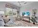 Bright living room featuring a plush blue sofa, rug, and large window at 1301 Backspin Dr, Englewood, FL 34223