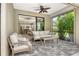 Cozy screened-in patio with comfortable seating and views of the lush backyard, seamlessly connected to the indoors at 1301 Backspin Dr, Englewood, FL 34223