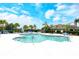 Beautiful community pool featuring ample seating, lush landscaping, and clear blue water at 1301 Backspin Dr, Englewood, FL 34223