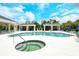 Inviting community pool and hot tub with poolside cabanas and comfortable seating areas at 1301 Backspin Dr, Englewood, FL 34223