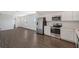 Open-concept kitchen with stainless appliances, white cabinets, and modern flooring at 13125 Bayberry Way, Parrish, FL 34219
