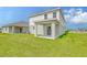 A home's backyard features green grass, an outdoor sitting area, and an attached garage at 13129 Bayberry Way, Parrish, FL 34219
