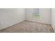A bright bedroom features neutral carpet, walls, a window, and baseboard trim at 13129 Bayberry Way, Parrish, FL 34219