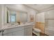 Bathroom features a double sink vanity, a large mirror, tile floors, and a shower/tub combination with a striped curtain at 13133 Bayberry Way, Parrish, FL 34219