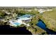 Community amenities featuring a sparkling pool, tennis courts, and clubhouse surrounded by lush greenery at 1316 Perico Point Cir, Bradenton, FL 34209