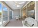 Enclosed lanai featuring a ceiling fan, comfortable seating, and serene waterfront views for relaxation at 1316 Perico Point Cir, Bradenton, FL 34209