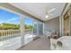 Enclosed lanai features a ceiling fan, comfortable seating, and serene water views at 1316 Perico Point Cir, Bradenton, FL 34209