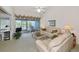 Bright living room with white sofas, and access to the screened lanai with views at 1316 Perico Point Cir, Bradenton, FL 34209